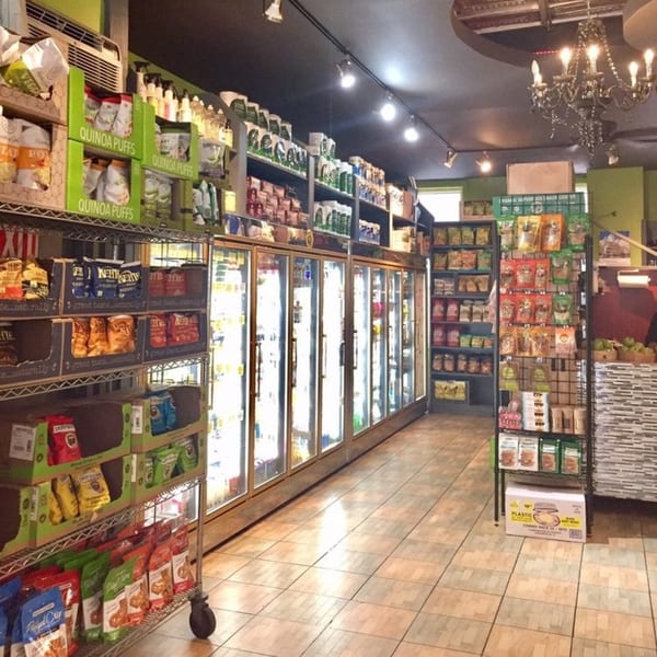 Interior of Brooklyn Standard, an American restaurant, showing aisles of packaged snacks, drinks, and refrigerated items.
