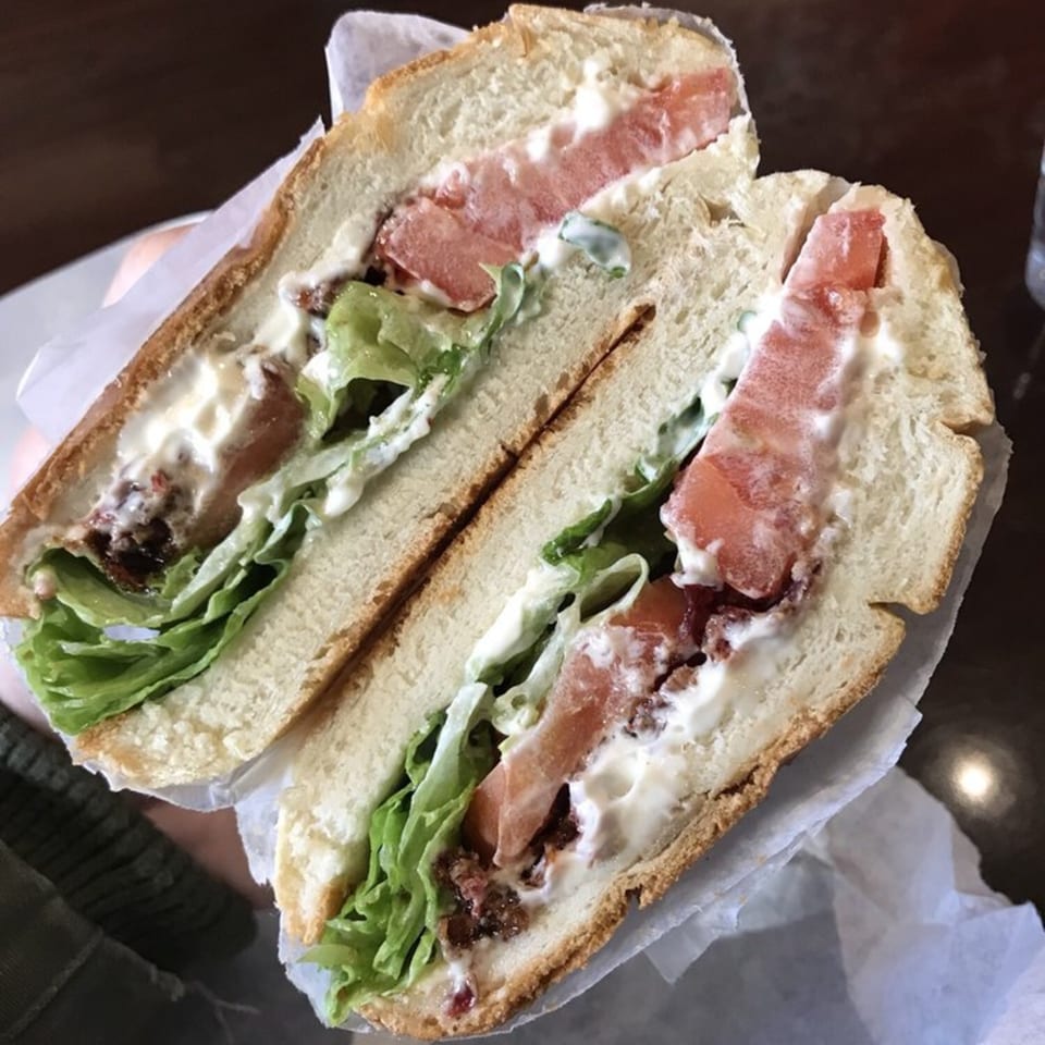 A Brooklyn Standard BLT sandwich, cut in half, with bacon, lettuce, tomato, and mayonnaise.